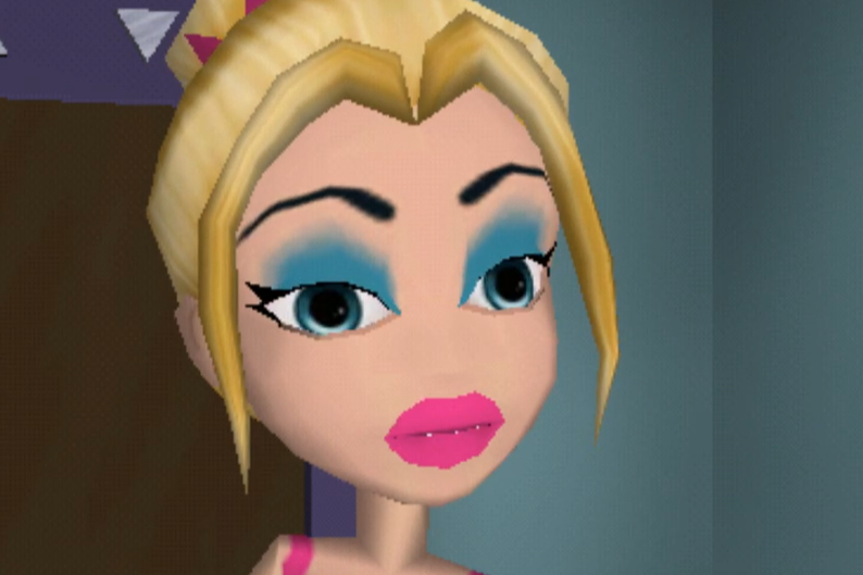 Kirstee is a white blonde woman with messy blue eyeshadow. She wears a pink dress and lipstick. Her hair is in a bun with a small pink tiara around it. Her eyes are blue.